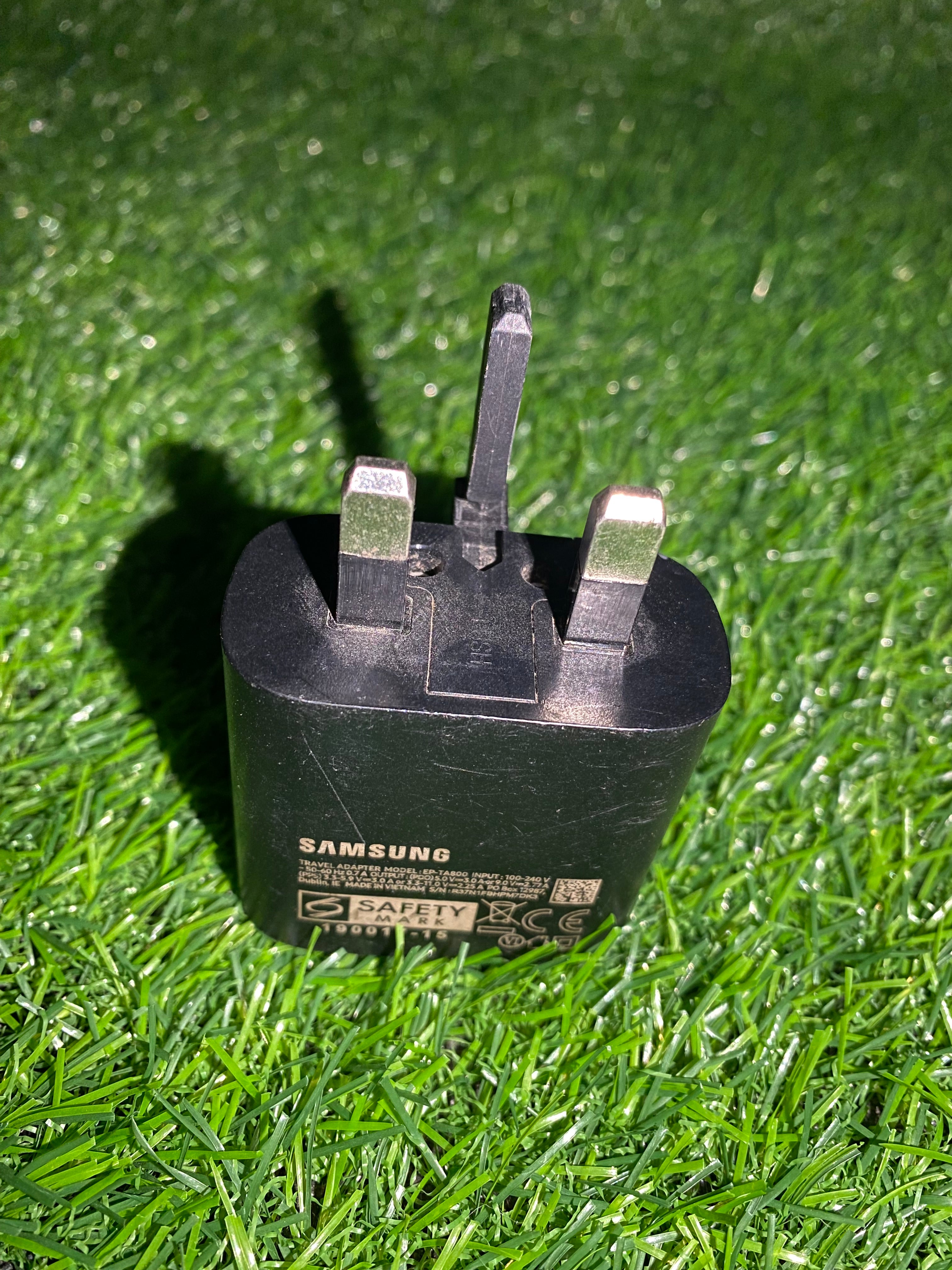 Black plug on a green grass background